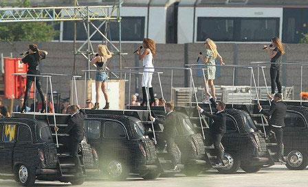 The Spice Girls were photographed dancing atop black London taxis.