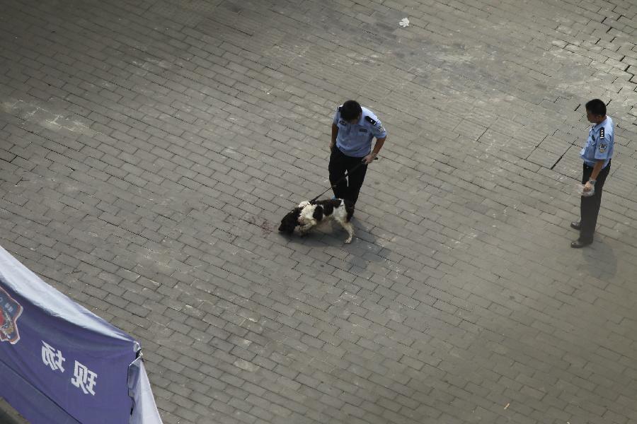 Policemen investigate the scene of an armed robbery in front of a bank in southwest China's Chongqing Municipality, Aug. 10, 2012. One person was shot dead and two others were injured in an armed robbery in Chongqing Municipality Friday morning. Police have launched a manhunt for the serial killer believed to be behind the robbery.