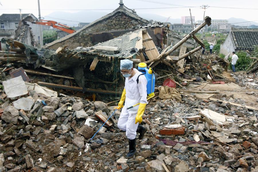 A medical worker sprays disinfectant at the accident site after the dam of the Shenjiakeng Reservoir breached in Daishan County, east China's Zhejiang Province, Aug. 10, 2012. All-round rescue work was started after the collapse of the Shenjiakeng Reservoir on Friday, which claimed 11 lives and injured 27 people.