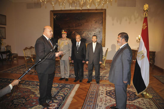 Egypt's President Mohamed Mursi (R) observes as newly appointed Vice-President, Judge Mahmoud Mekki receives his orders at the presidential palace in Cairo, August 12, 2012. [Photo/Agencies]