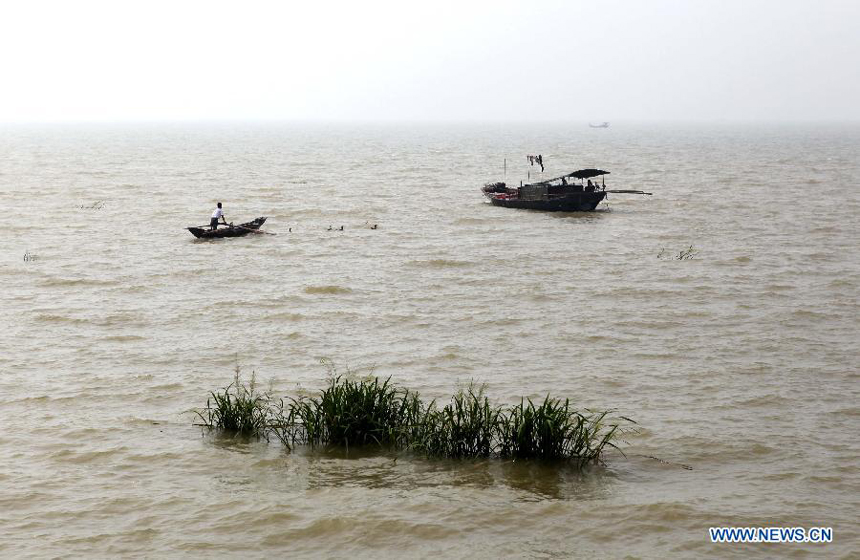 A fisherman works on the Poyang Lake in Duchang County, east China&apos;s Jiangxi Province, Aug. 11, 2012. The water level of the Poyang Lake, the country&apos;s largest freshwater lake, stood higher than the alert level on Sunday, due to typhoon-triggered torrential rainstorms.