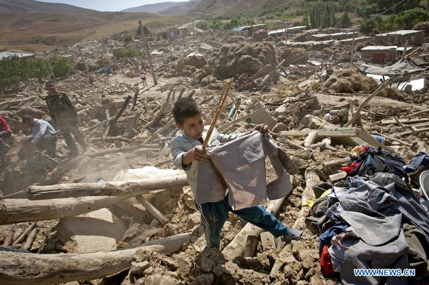 A boy searches for his clothes after an earthquake in Varzaqan in northwest Iran, on Aug. 12, 2012. The death toll of Saturday&apos;s strong twin quakes in northwest Iran has risen to some 300, the semi-official Fars news agency cited an official as saying on Sunday.