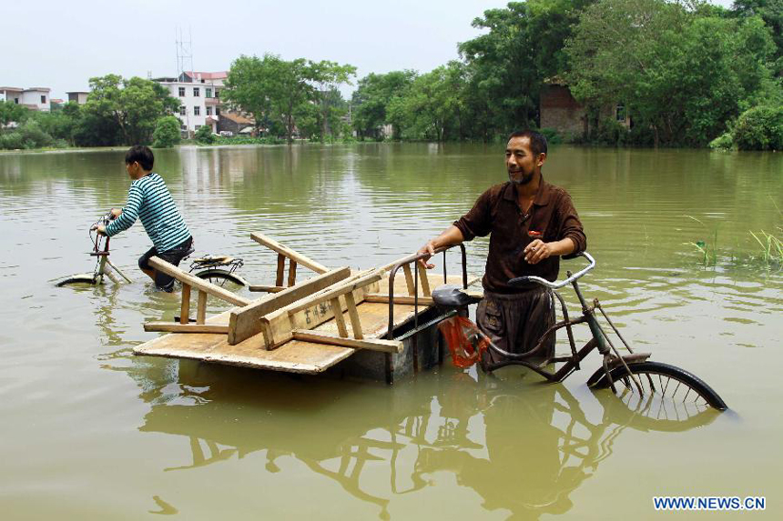 Villagers wades through a flooded road after the wallop of Tyhpoon Haikui in Yexing Village of Hougang Town in Leping City, east China&apos;s Jiangxi Province, Aug. 12, 2012. The typhoon have had an impact on 1.13 million people in the province and China&apos;s central authorities initiated a level-four emergency plan on Saturday in response to torrential rains and flooding caused by typhoon Haikui in Jiangxi province. 