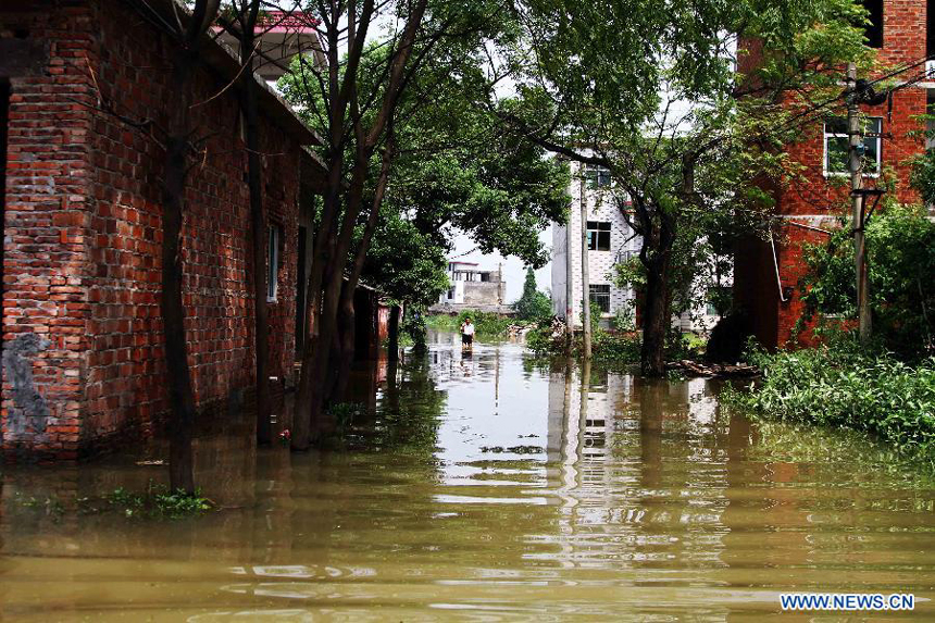 A passenger wades through a flooded road after the wallop of Tyhpoon Haikui in Yexing Village of Hougang Town in Leping City, east China&apos;s Jiangxi Province, Aug. 12, 2012. The typhoon have had an impact on 1.13 million people in the province and China&apos;s central authorities initiated a level-four emergency plan on Saturday in response to torrential rains and flooding caused by typhoon Haikui in Jiangxi province. 