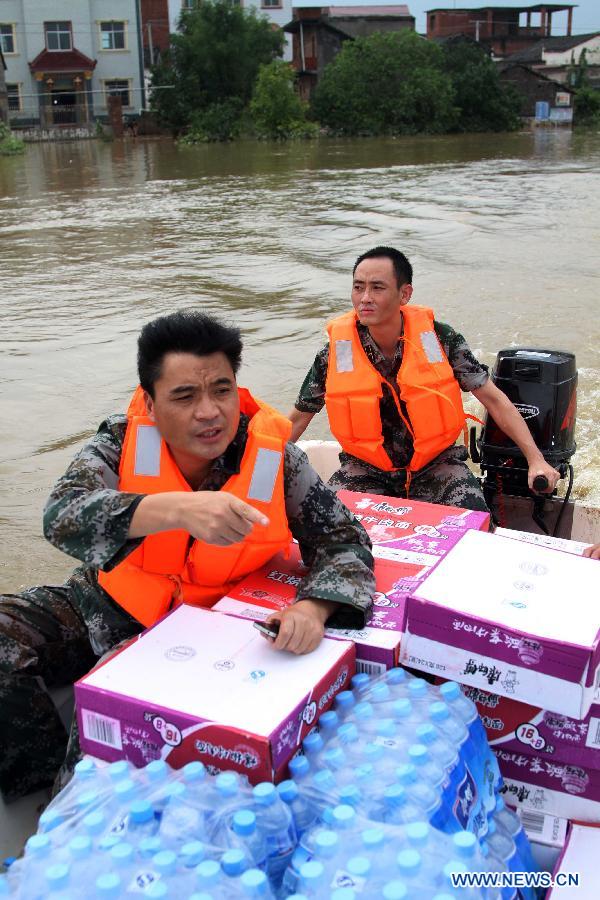 Soldiers carry drinkable water and food on a boat to relieve villagers after the wallop of Tyhpoon Haikui in Gangbian Village of Lin&apos;gang Town in Leping City, east China&apos;s Jiangxi Province, Aug. 11, 2012. The typhoon have had an impact on 1.13 million people in the province and China&apos;s central authorities initiated a level-four emergency plan on Saturday in response to torrential rains and flooding caused by typhoon Haikui in Jiangxi province.