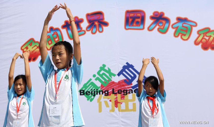 Students perform for donators and volunteers during a charitable activity in Shuren School, a school for the children of migrant workers, in Beijing, capital of China, Aug. 12, 2012. 