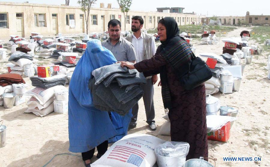 An Afghan woman receives aid which was donated by United Nation for the poor people in Balkh province, Afghanistan, Aug. 12, 2012. 448 families would receive the aid.