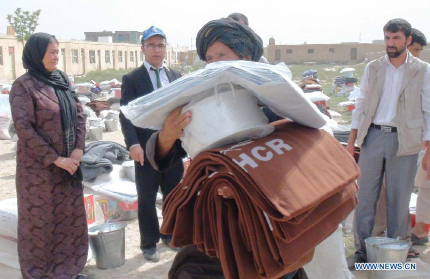 Afghans receive aid which was donated by United Nation for the poor people in Balkh province, Afghanistan, Aug. 12, 2012. 448 families would receive the aid.