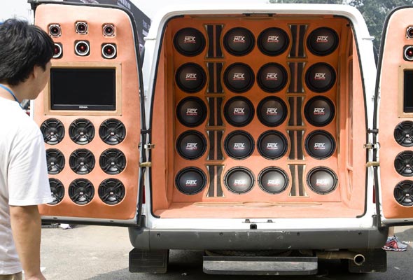 A visitor looks at the stereos on a modified car during the All in Tuning All in Caravaning Show China 2012 on Aug 10, 2012, at the National Agriculture Exhibition Center, Beijing. [Photo/Xinhua]