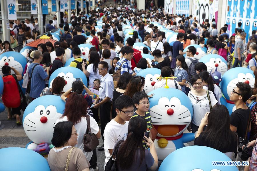 Citizens view models of Doraemon, a famous cartoon character, at an exhibition in Hong Kong, south China, Aug. 14, 2012. A total of 100 Doraemon models were exhibited. (Xinhua/Liu Yongdong) 