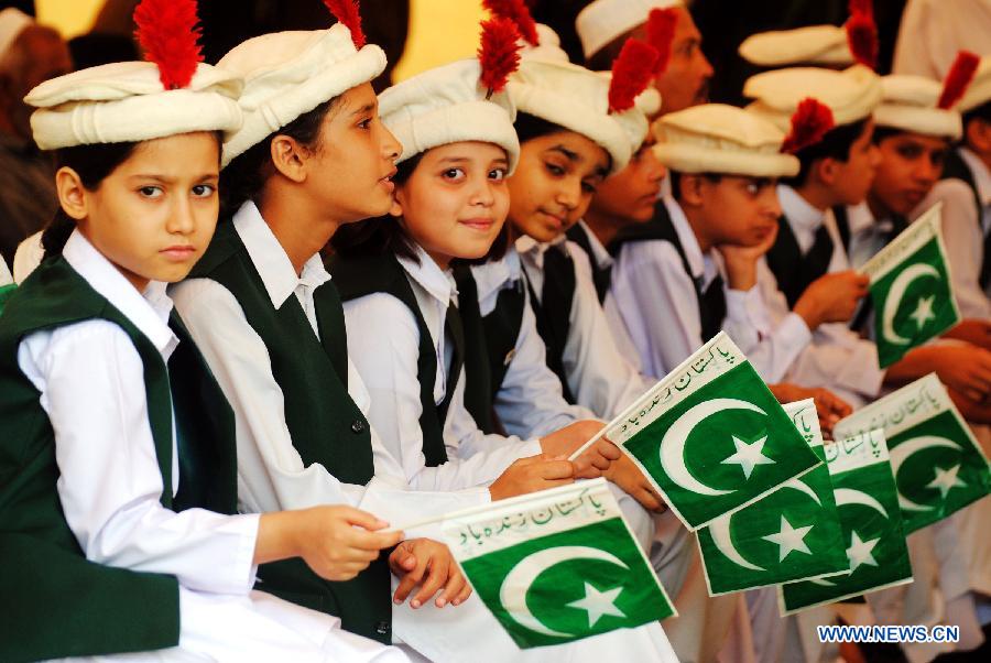 Pakistani students hold national flags during a ceremony to celebrate 65th Pakistan's Independence Day in northwest Pakistan's Peshawar on Aug. 14, 2012.