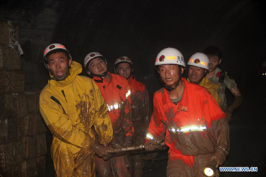 Firefighters rescue a citizen at an accident site after a road collapsed at Liaoyang Street of Harbin City, northeast China's Heilongjiang Province, Aug. 14, 2012. Two people were confirmed dead and two others injured when a roadbed collapsed at Liaoyang Street in Nangang District of Harbin City on Tuesday.