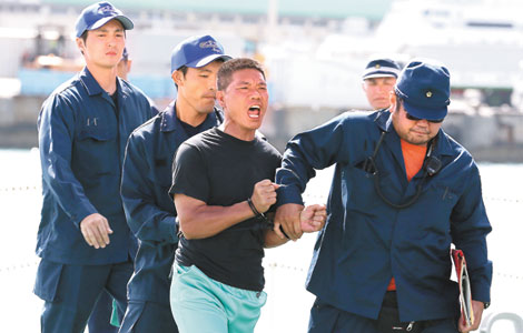 An activist who landed on the Diaoyu Islands is taken into police custody in Naha, the capital of Okinawa, on Thursday. [Agencies] 