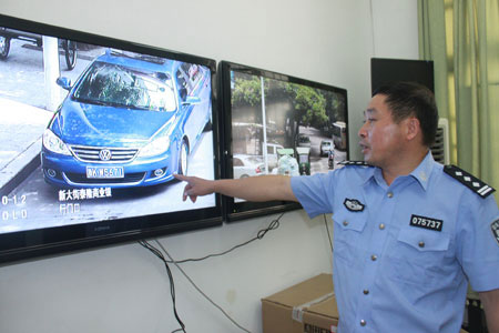The undated photo shows that a traffic police points to a parking violation on a CCTV footage from the surveillance camera in the Qingtian County of Zhejiang province. [Photo: qtjjdd.com]