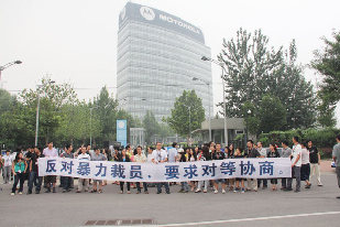 Staff members of Motorola Mobility Holdings Inc in Beijing protest in front of the company's office building on Friday demanding 'consultation on an equal footing'. [Photo / China Daily] 