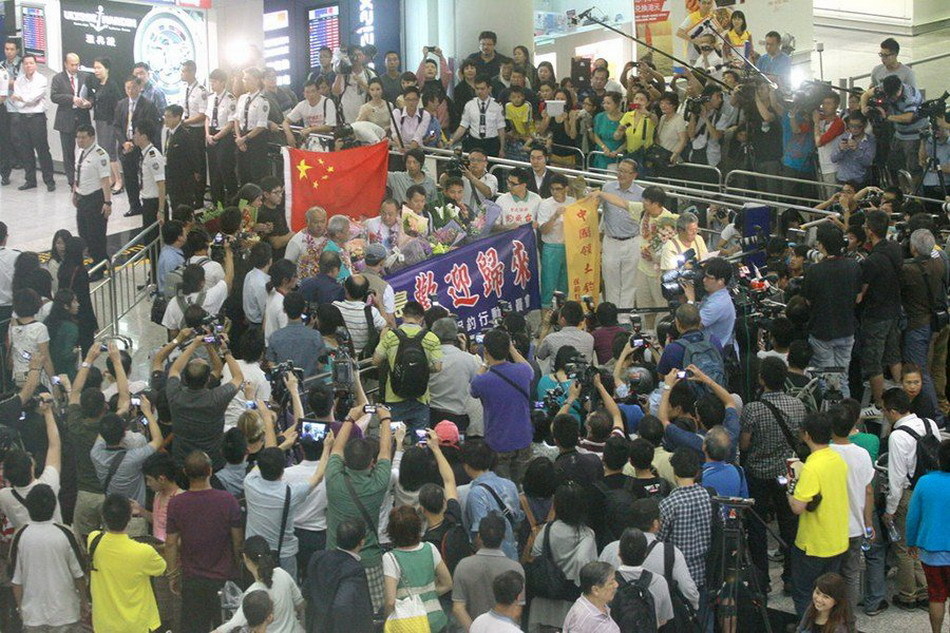 Seven of 14 Chinese nationals who were illegally detained by Japan after landing on the Diaoyu Islands arrive at Hong Kong International Airport at around 7:50 p.m. local time, August 17, 2012. All the 14 activists have been released. The other group of seven have also boarded a plane of Japan Coast Guard to fly to Ishigaki Island where their vessel was detained and will return later by their boat.