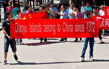 Protesters hold up banners and Chinese flags outside the Japanese Embassy in Beijing in protest at the landing of a group of Japanese nationalists on one of the Diaoyu Islands in the East China Sea.