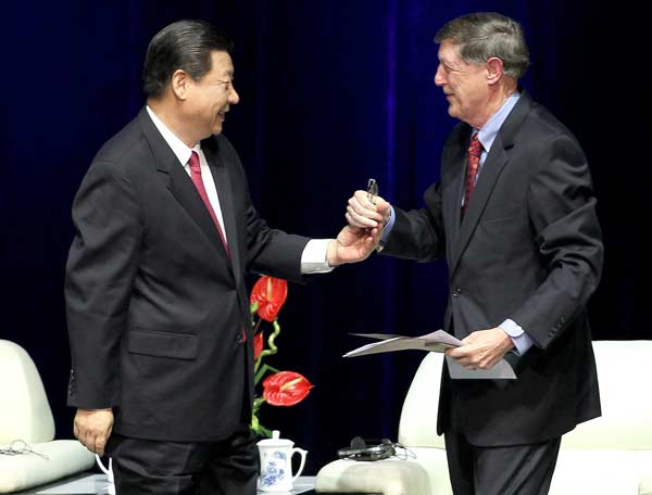 Vice-President Xi Jinping returns glasses dropped by Robert Williams, the president of the International Astronomical Union, at the union’s general assembly in Beijing on Tuesday. [Feng Yongbin/China Daily]