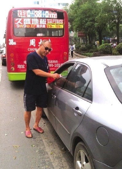 A driver surnamed Zhang said 'someone suddenly knocked his window' when he was waiting for the lights to turn green demanding payment. He had stopped for the red light but had encroached on the crosswalk.[ Photo / dayoo.com]