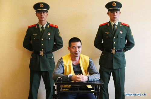 Naw Kham (C), a drug lord suspected of masterminding the murders of 13 Chinese sailors on Oct. 5, 2011, is interrogated by Chinese and Myanmar military and police officers in Kunming, capital of southwest China's Yunnan Province, Aug. 22, 2012. 