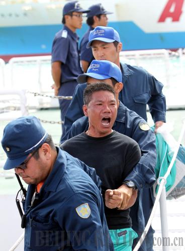 Japan's Okinawa prefectural police escort an activist on August 16, one day after a group of Chinese demonstrators were arrested for protesting on the Diaoyu Islands (CFP)