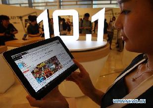 A model shows the new Samsung Galaxy Tab 10.1 tablet computer during the launch event at the head office of Samsung Electronics Corp. in Seoul, South Korea, on July 20, 2011. Faster, larger and lighter than Apple Inc.'s iPad, the Galaxy Tab 10.1 is Samsung's second tablet PC, following the 7-inch Galaxy Tab in October 2010.[Photo/Xinhua]