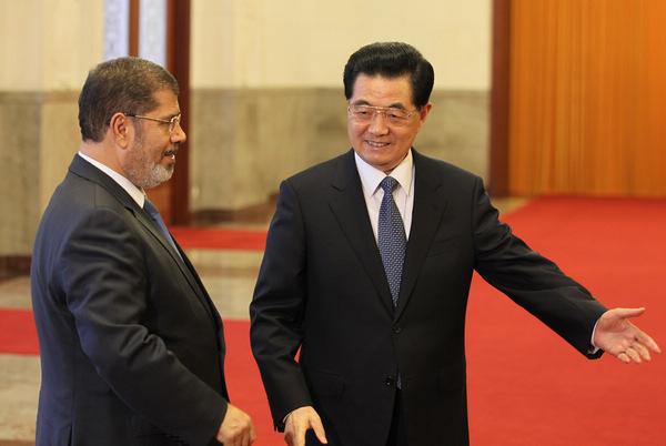 President Hu Jintao meets his Egyptian counterpart Mohamed Morsi in Beijing on Tuesday. China is one of the first countries Morsi chose to visit since he assumed office in June. Both leaders vowed to enhance cooperation, such as encouraging more Chinese companies to invest in Egypt. [Photo by Wu Zhiyi / China Daily]