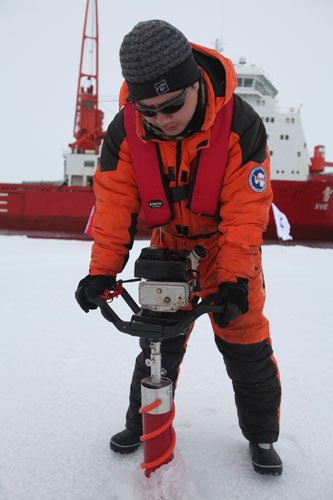 A scientific researcher breaks ice at a Chinese research station in the Arctic Ocean, Aug 29, 2012.