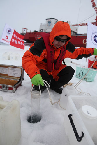 A scientific researcher collects sea water under the ice in the Arctic Ocean, during China's fifth arctic expedition on Aug 29, 2012. [Photo/Xinhua]