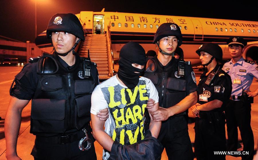Suspect Xiong Yi (C) is sent from an airplane under escort in Wuhan, Hubei Province, on Sept. 2, 2012. Chinese police have seized him for allegedly sending a threatening message which caused a domestic flight to divert on Thursday. Xiong was caught Saturday afternoon in a hotel in Dongguan, Guangdong.