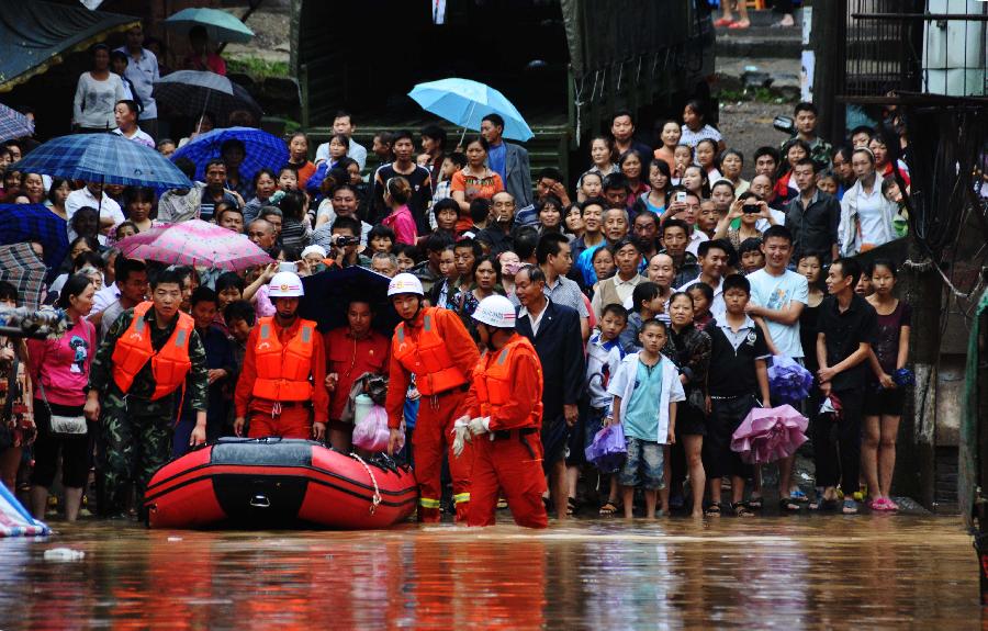 Public security and fire fighters prepare to steer a boat to help transfer residents besieged by floods in Enyang Town, Bazhong City, Sichuan Province, on Sept. 1, 2012. The heavy rainfalls since Aug. 30 caused floods in part of Sichuan Province, forcing 62,600 people to evacuate and destroying 8,500 houses