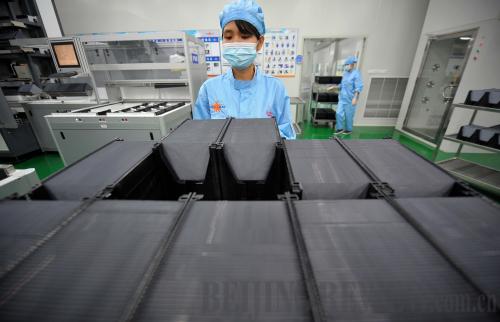 A worker at Yingli Solar in Hainan Province processes silicon chips on August 22 [Photo/Beijing Review]