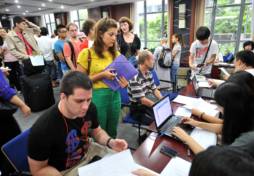 International students go through enrollment procedures at Nanjing University in Nanjing, Jiangsu Province, Sept. 3, 2012. Nearly 3,000 international students from more than 60 countries and regions were admitted to Nanjing University this year. [Xinhua photo]