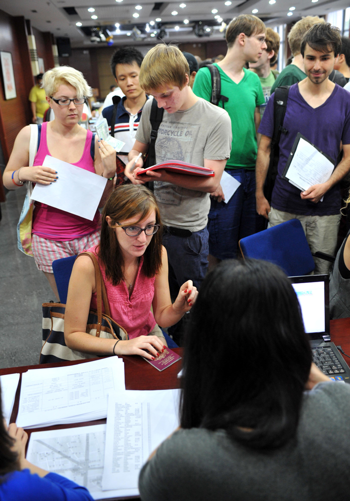 International students go through enrollment procedures at Nanjing University in Nanjing, Jiangsu Province, Sept. 3, 2012. Nearly 3,000 international students from more than 60 countries and regions were admitted to Nanjing University this year. [Xinhua photo]