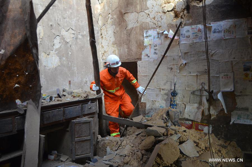 A rescuer searches for victim in a damaged house in Weining County, southwest China's Guizhou Province, Sept. 7, 2012. A strong earthquake hit the border area of Yiliang County of Yunnan and Weining County of Guizhou Province at 11:19 a.m. Some 6,300 people were afflicted and more than 1,540 houses were damaged in Weining till 5 p.m. Friday.