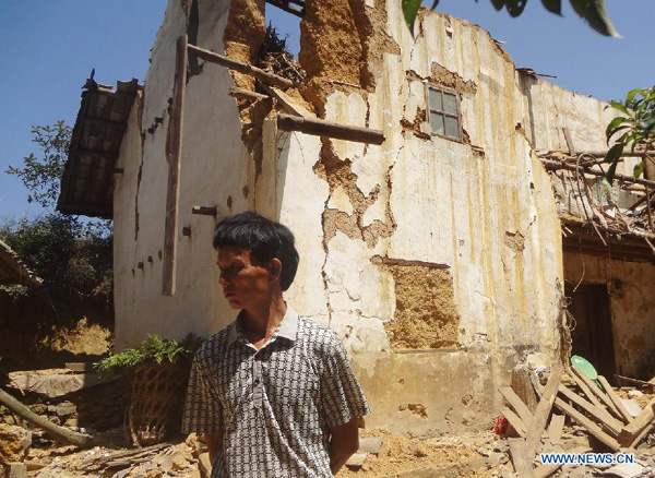 A man stands in front of a damaged house in Xinlong Village of Weining County, southwest China's Guizhou Province, Sept. 7, 2012. A 5.7 magnitude earthquake hit the border area of Yiliang County of Yunnan and Weining County of Guizhou Province at 11:19 a.m. The quake has afflicted some 6,300 people and damaged more than 1,540 houses in Weining till 5 p.m. Friday. [Photo/Xinhua] 