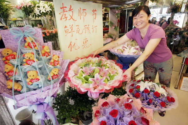 A flower shop owner in Nanjing, capital city of Jiangsu province, showing her well-packaged bundles of flowers and expecting good business a few days ahead of the country's Teachers' Day. [Photo/China Daily]