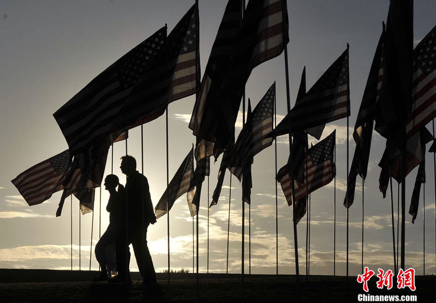 People walk amongst US national flags erected by students and staff from Pepperdine University to honor victims of the 9/11 attacks, in Malibu on September 9, 2012.