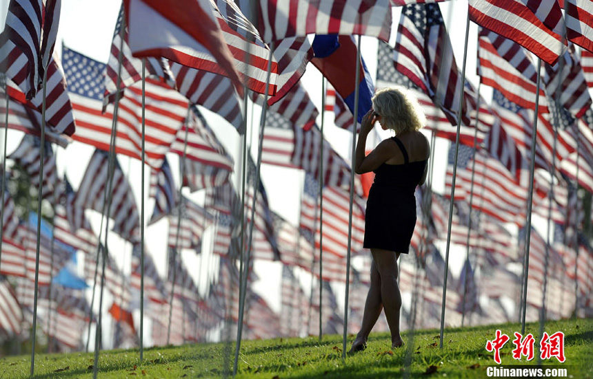 A lady walks amongst US national flags erected by students and staff from Pepperdine University to honor victims of the 9/11 attacks, in Malibu on September 9, 2012.