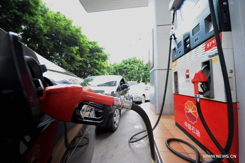 A gasoline pump rests in the tank of a car at a petrol station in Chongqing Municipality, southwest China, Sept. 10, 2012. China will raise the retail prices of gasoline by 550 yuan (85.75 U.S. dollars) per tonne and diesel by 540 yuan per tonne starting Tuesday. The benchmark retail price of gasoline will be lifted by 0.41 yuan per liter and diesel by 0.46 yuan per liter.