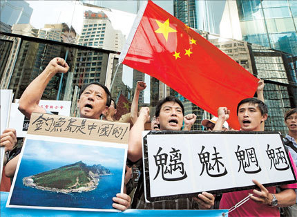 Protesters chant slogans outside the Japanese Consulate General in Hong Kong yesterday as they hold up a picture of the Diaoyu Islands with words reading: 'Diaoyu belongs to China' and a sign saying: 'Evil spirits of mountains and rivers.'
