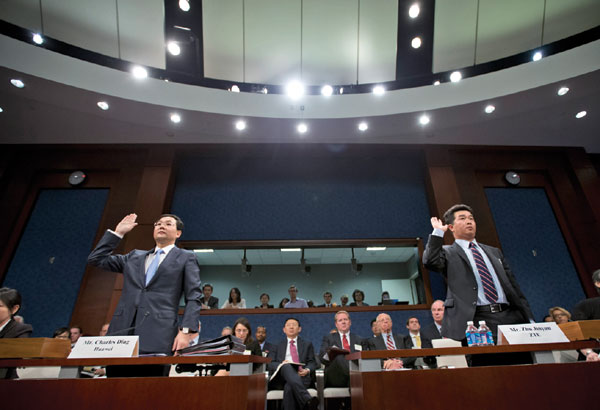 Charles Ding, Huawei Technologies Ltd senior vice-president for the US (left), and Zhu Jinyun, ZTE Corporation senior vice-president for North America and Europe, are sworn in on Capitol Hill in Washington. [Photo/Agencies] 