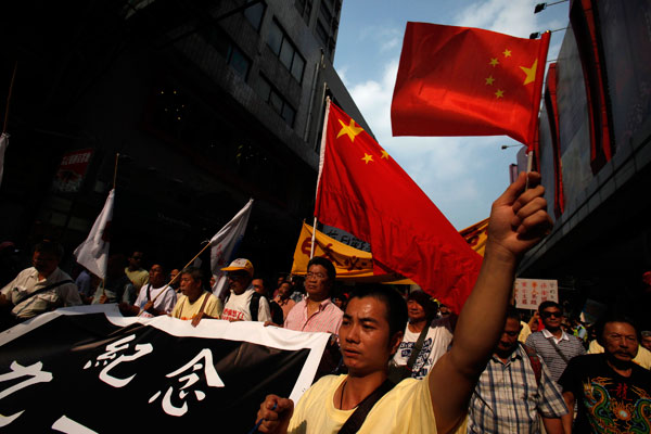 Demonstrators in Hong Kong display national flags during a protest on Sunday against Japan's decision to 'buy' the Diaoyu Islands. [Agencies via China Daily]