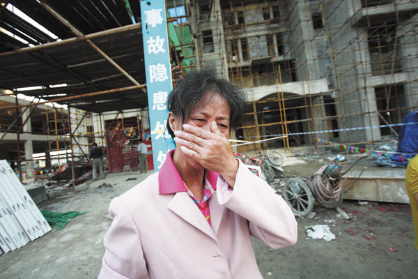 A relative of Xu Weixi weeps outside a construction site. Xu, along with 18 others, was killed at the site on Thursday when an elevator fell 100 meters to the ground in Wuhan. 