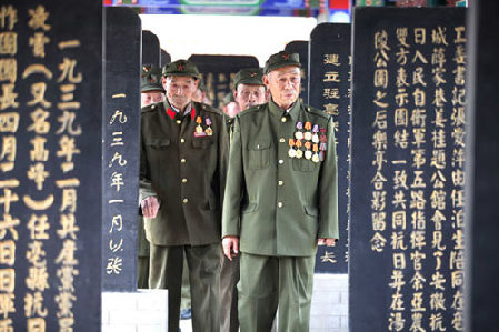 Chinese veterans stand amid the tombstones of soldiers who were killed during the war against the Japanese invaders in the 1930s and 1940s, at a martyr cemetery in Bozhou, in East China's Anhui province, on Monday.[Photo/China Daily]