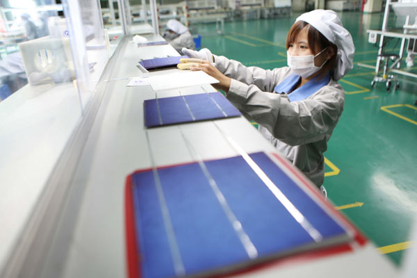 A woman works at a factory producing solar panels for the European market, in Jiangsu province, on Sept 6. The European Commission launched an anti-dumping investigation into made-in-China solar products in early September, forcing some Chinese factories to reduce production and lay off their workers. 