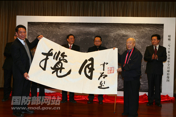 CPPCC National Committee members hold up a sign inscribed with the famous calligrapher Ouyang's characters representing 'the moon.'