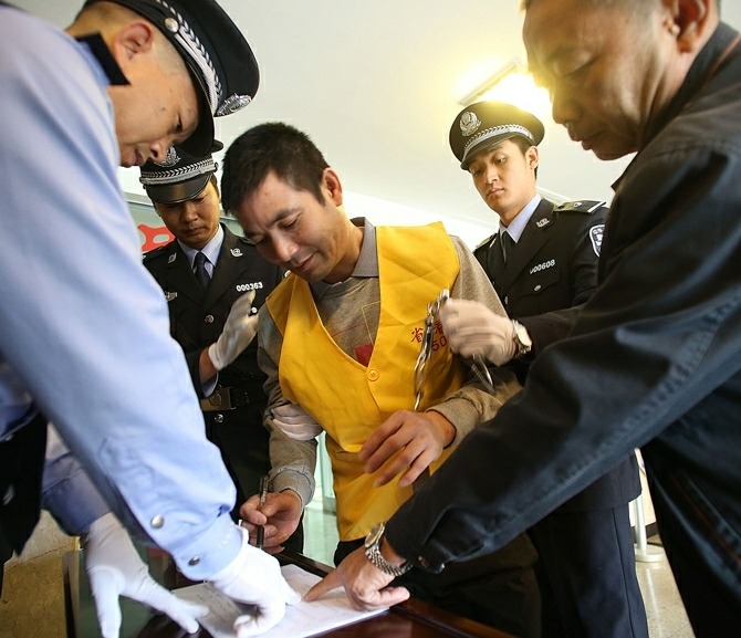 Naw Kham (C), a drug lord suspected of masterminding the murders of 13 Chinese sailors on Oct. 5, 2011, is interrogated by Chinese and Myanmar military and police officers in Kunming, capital of southwest China's Yunnan Province, Aug. 22, 2012.[Photo/Xinhua]