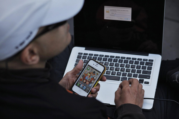 Hazem Sayed checks his Apple devices while waiting outside the Apple store on 5th Avenue, for Friday's iPhone 5 models to go on sale, in New York, Sept 19, 2012. [Photo/Agencies]