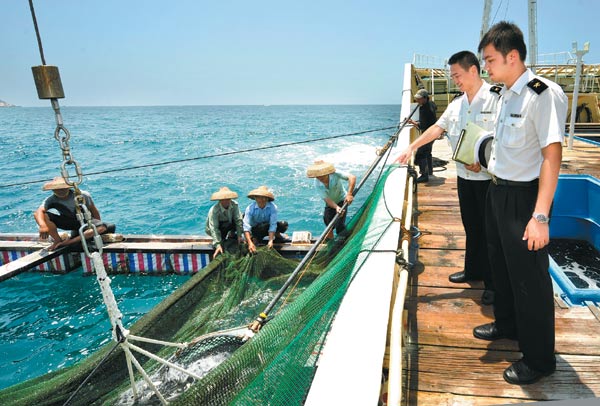 Customs officers inspect a vessel loaded with fish from Japan in Wenchang, Hainan province. China is strengthening customs inspections for Japanese products arriving at ports. [Song Guoqiang/For China Daily]